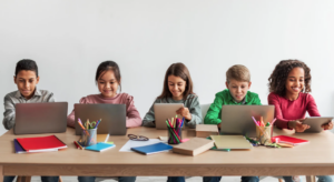 image shows a row of school kids working on their computers doing online fundraising