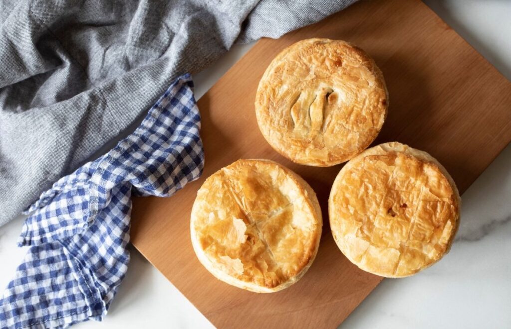 image shows a picture of three fundraising pies and savouries sitting on a board